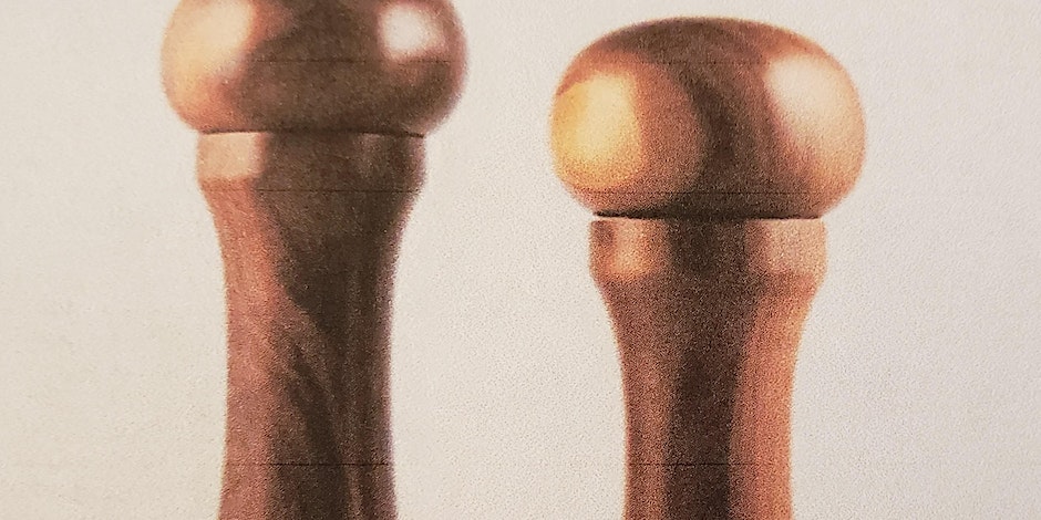 two brown wooden hand spun pepper mills